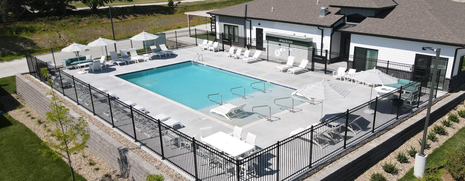 aerial view of swimming pool with lounge chairs and umbrellas around it